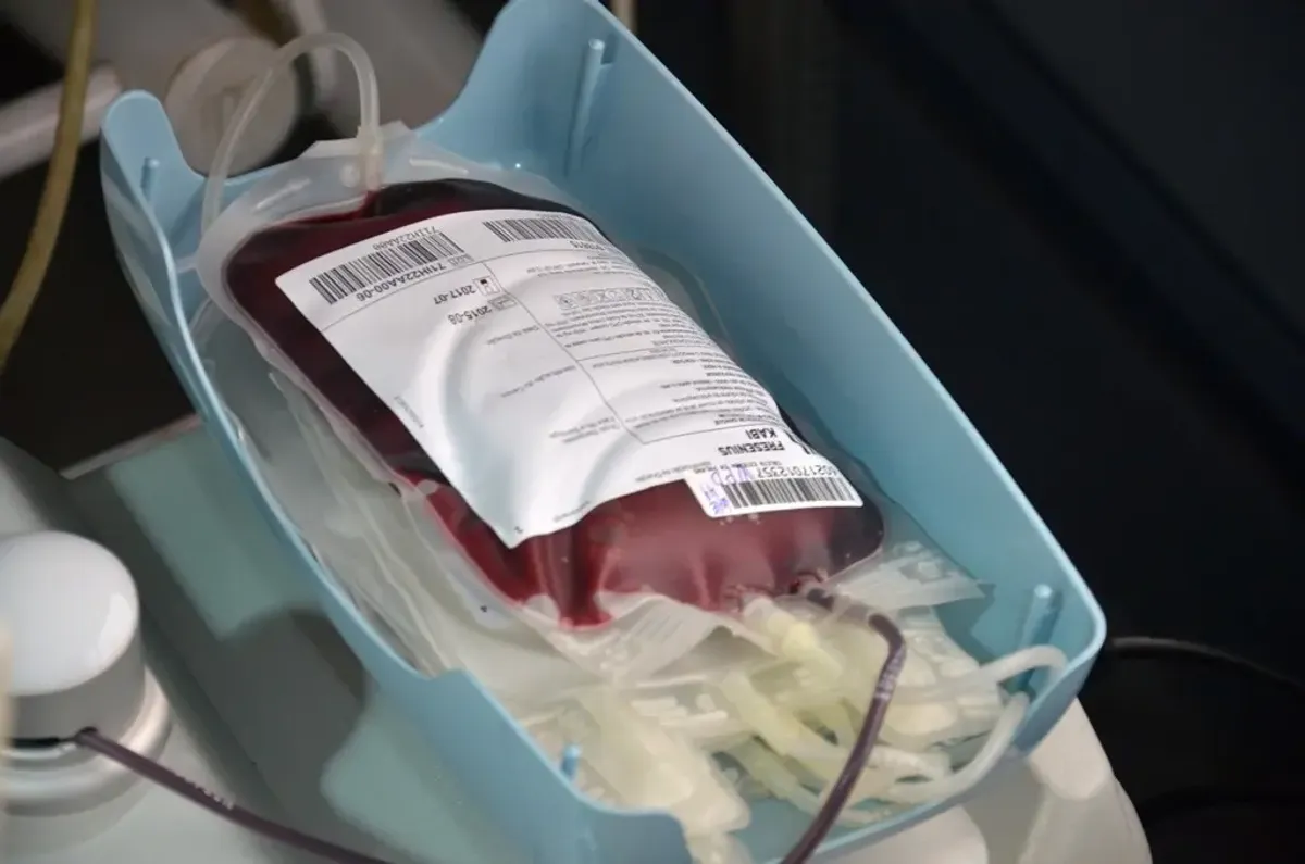 Pessoas doando sangue em um centro médico no Tocantins, com enfermeiros auxiliando os doadores, representando a necessidade urgente de reposição de estoque.
